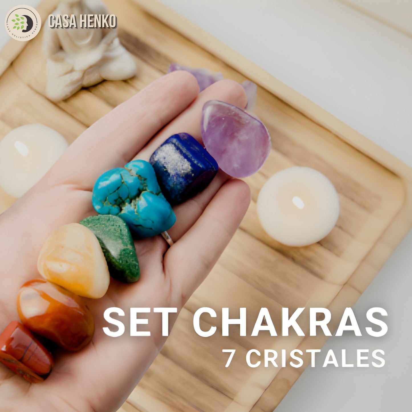 Mano sosteniendo set de 7 cristales de colores para chakras sobre bandeja de madera con velas blancas, Casa Henko.